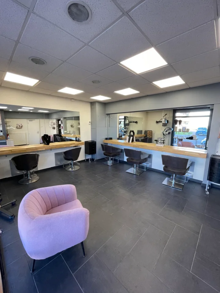 Salle de coiffure de l'Atelier des couleurs à Saint-Pol-sur-Mer, postes de travail et fauteuil rose